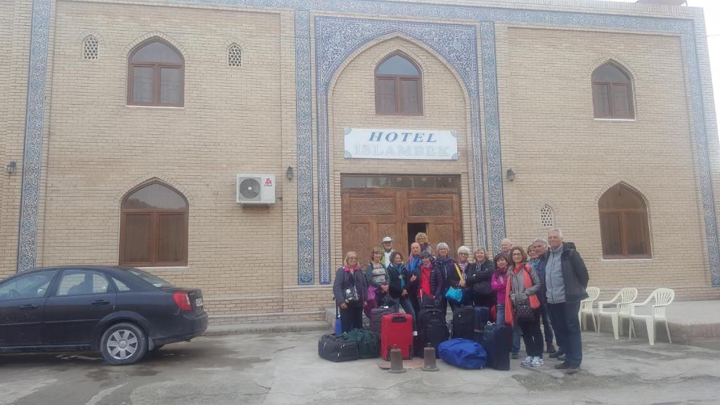 un grupo de personas de pie en frente de un edificio en Islambek Hotel & Travel, en Khiva