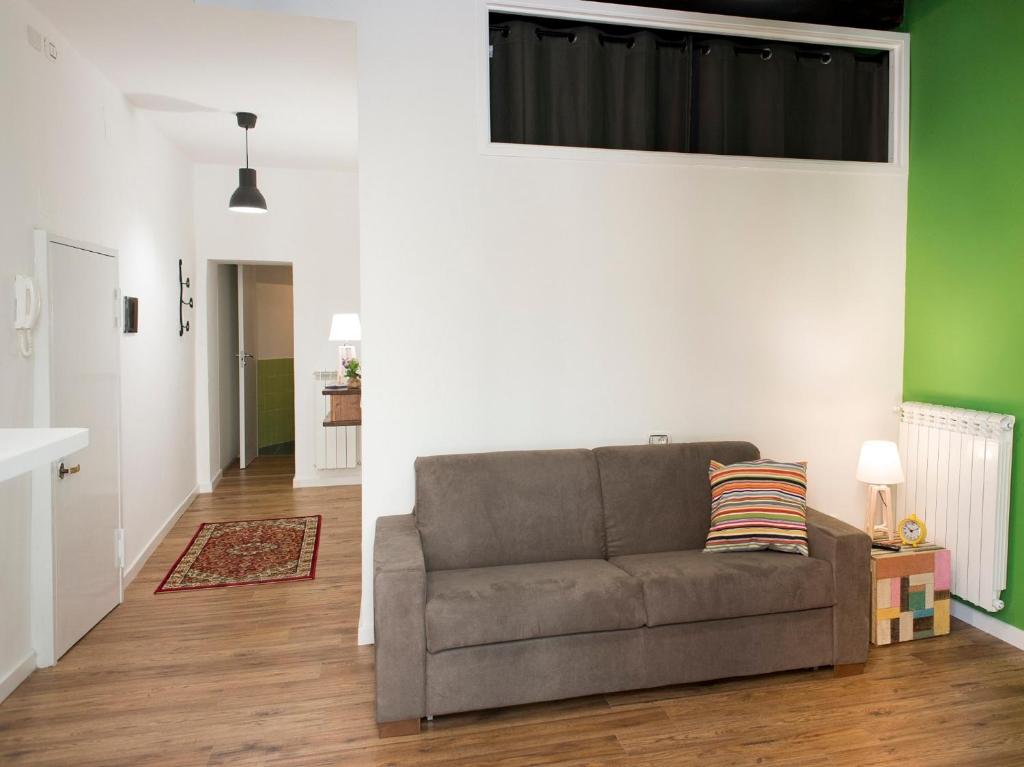 un soggiorno con divano e pareti verdi e bianche. di Sleep & Zupp Casa Olimpia a Napoli