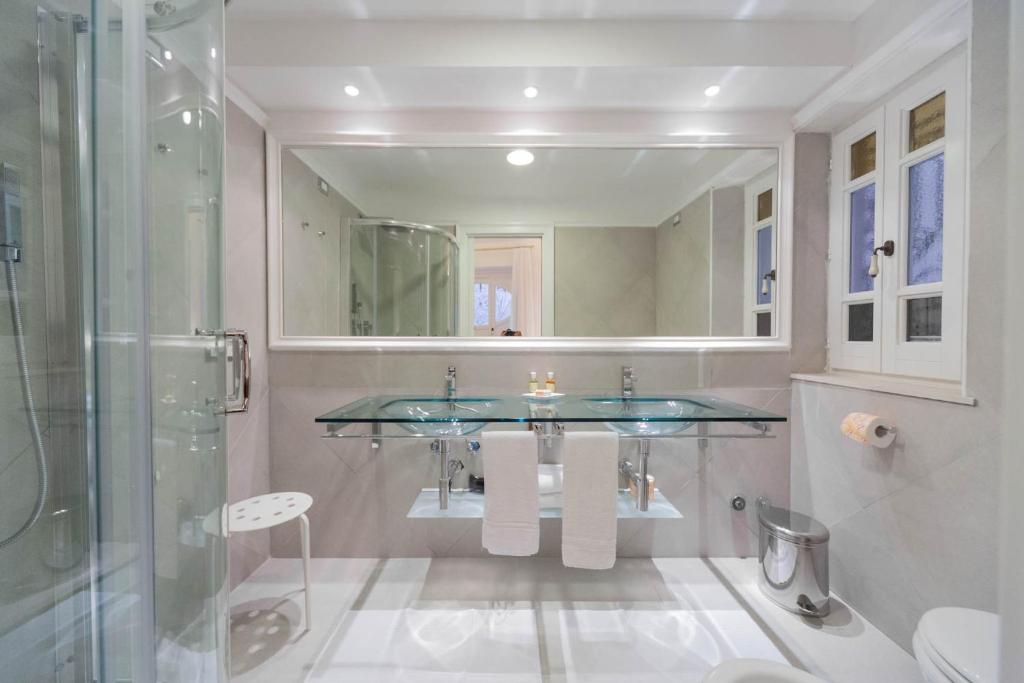 y baño con lavabo de cristal y ducha. en La Settima Luna Hotel, en Canneto