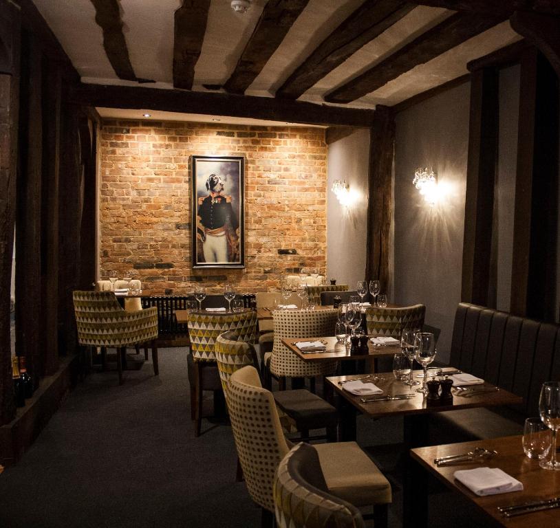 a restaurant with tables and chairs and a brick wall at The Swan Hotel Bar and Grill in Maldon