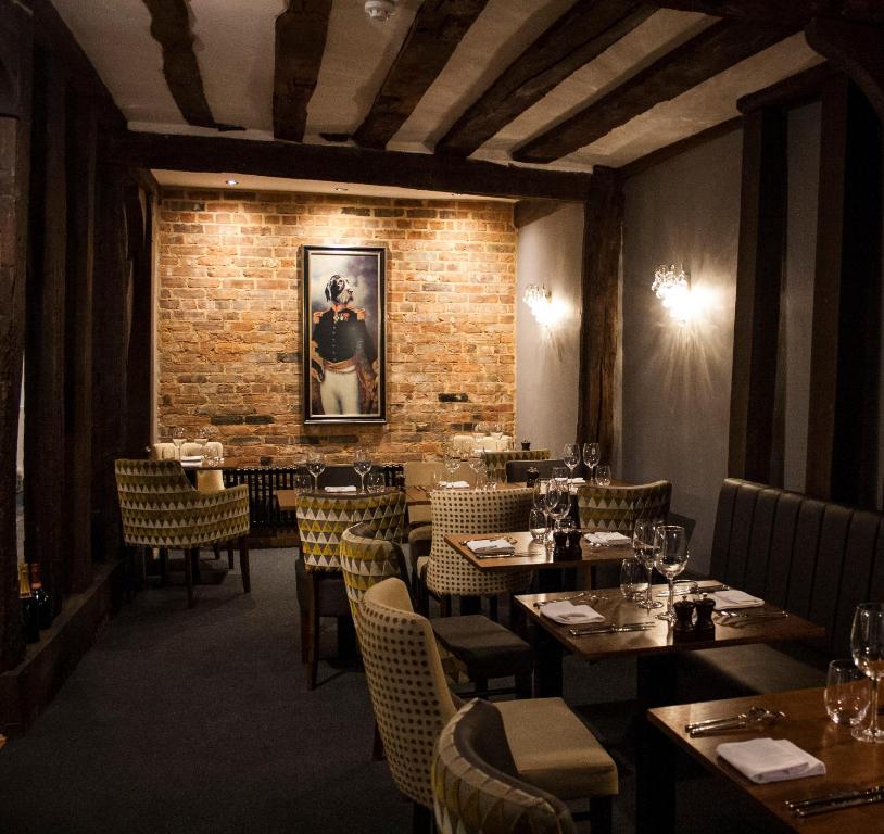 莫尔登The Swan Hotel Bar and Grill的一间有桌椅和砖墙的餐厅