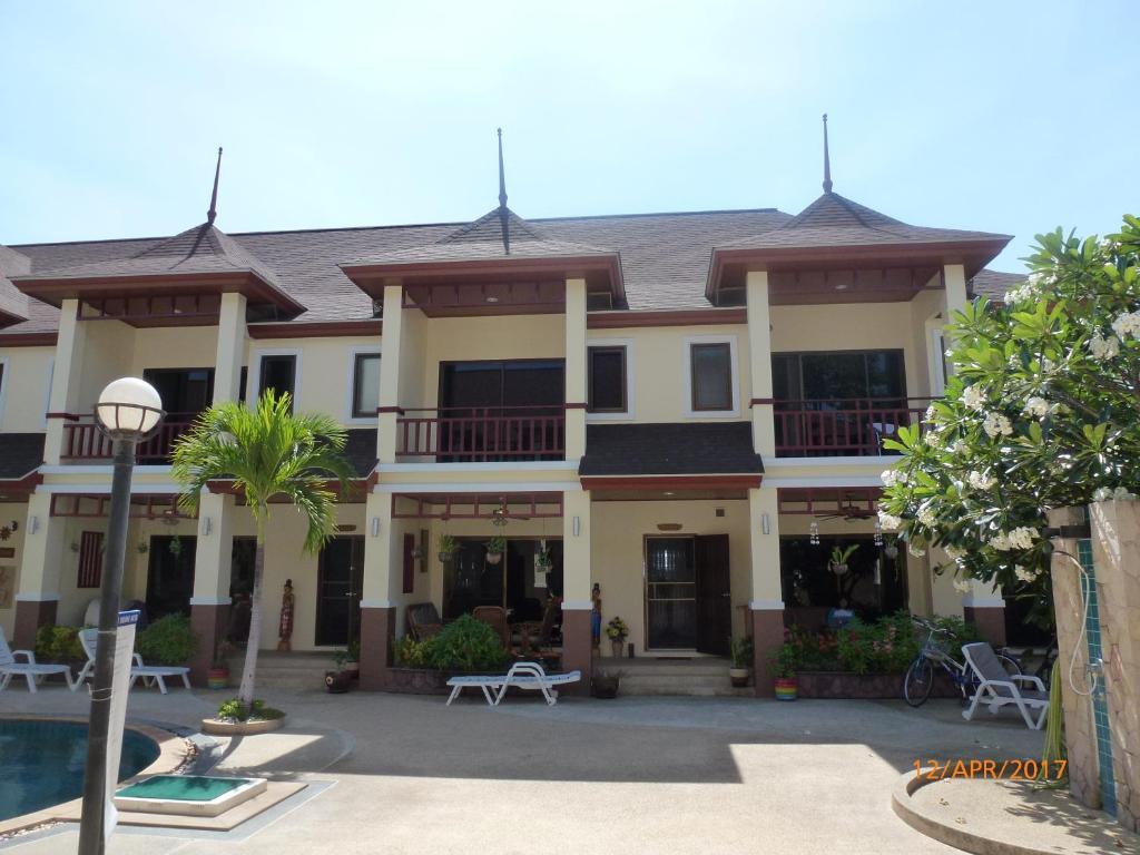 a large building with a pool in front of it at Organgrinder Thai Paradise South in Cha Am