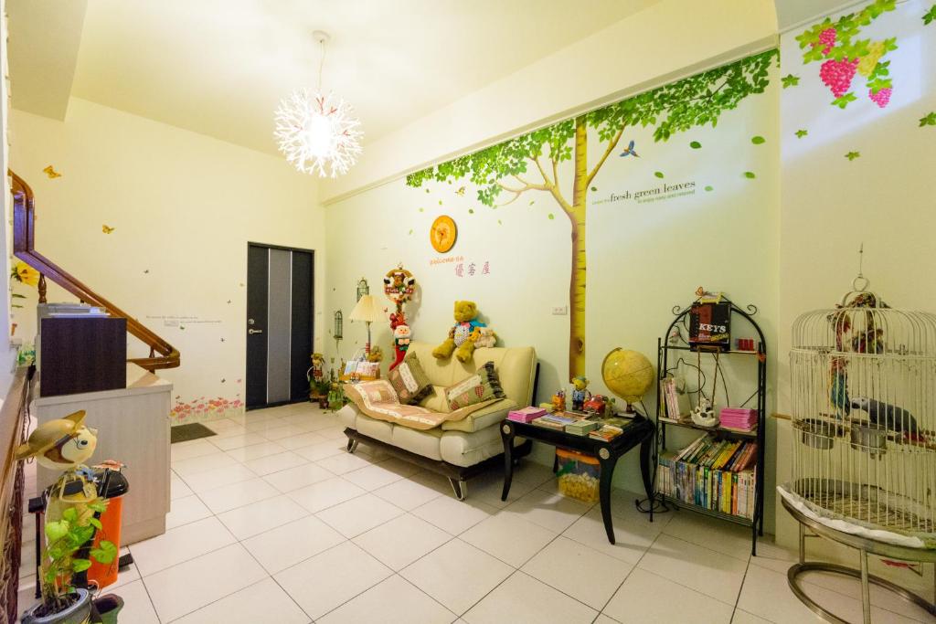 a room with a tree painted on the wall at Play House in Tainan