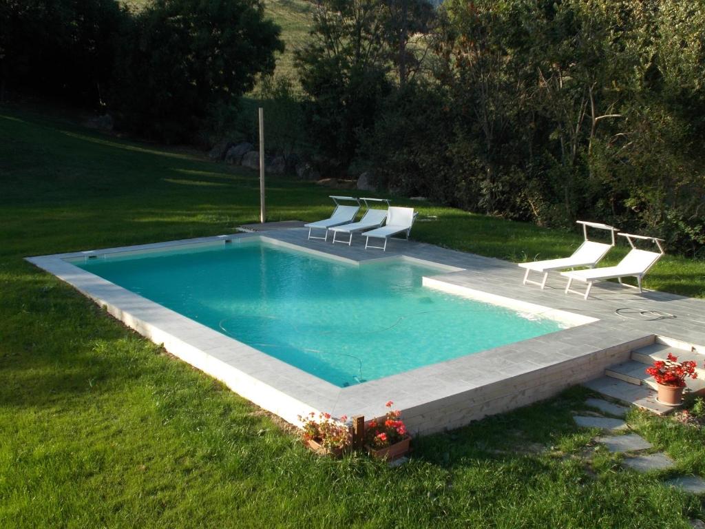 a swimming pool with lounge chairs in a yard at Country House "Locanda Le Querce" in Carpegna