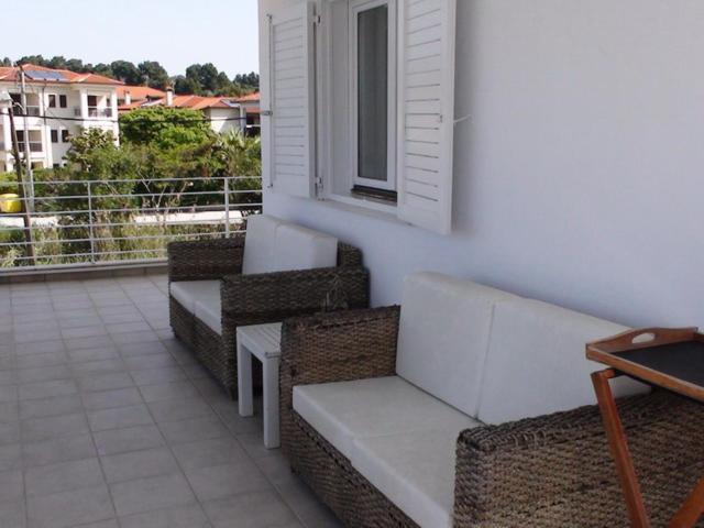 a balcony with three wicker chairs and a window at Marine House Andrianna -Adults only in Siviri
