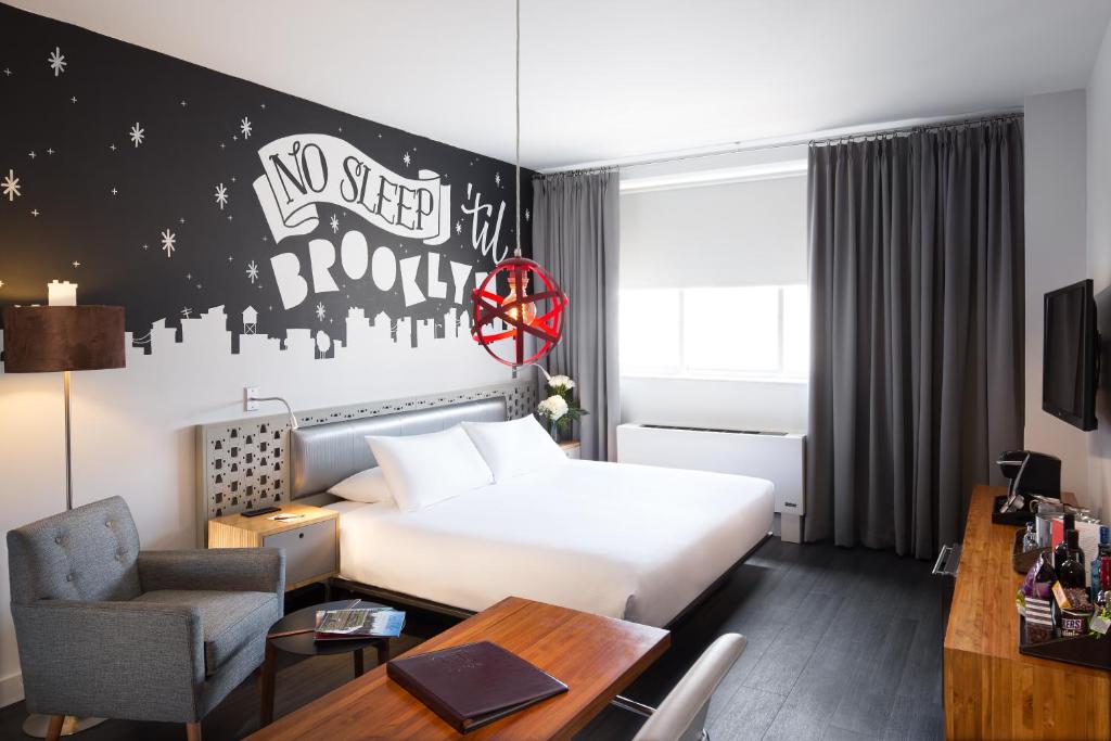 a hotel room with a large bed and a large window at NU Hotel in Brooklyn