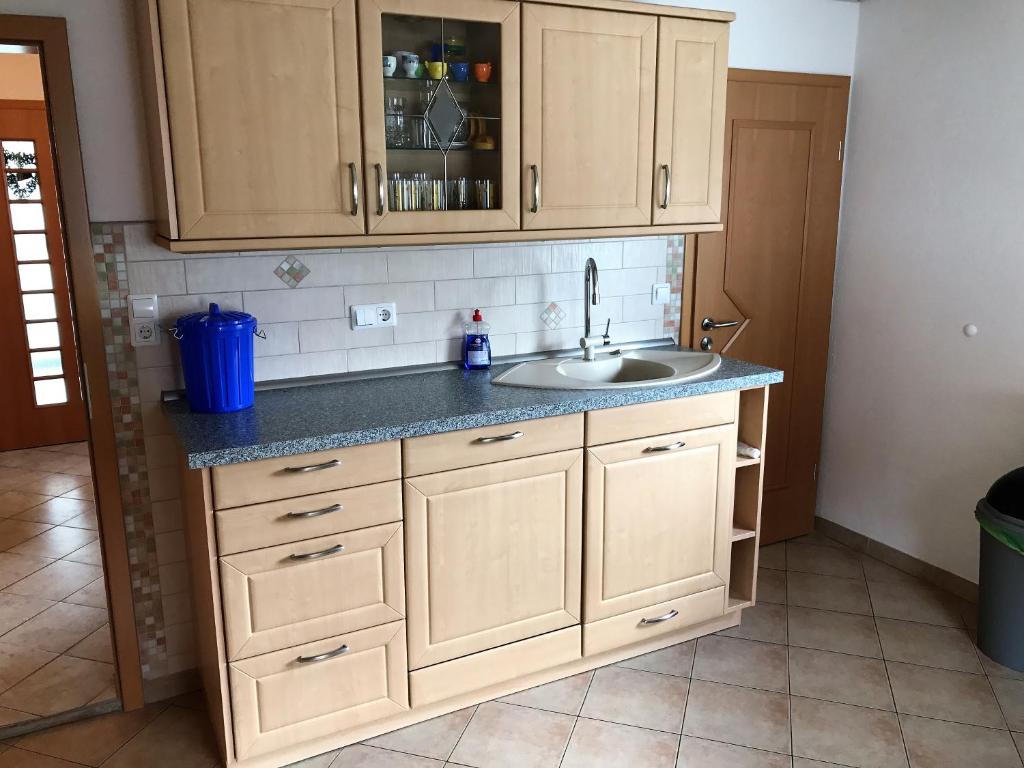 eine Küche mit Holzschränken und einem Waschbecken in der Unterkunft Ferienwohnung Familie Ober in Rotthalmünster