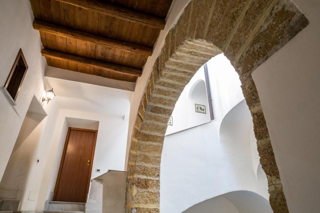 une arche dans un bâtiment avec des murs blancs et des plafonds en bois dans l'établissement B&B Addauru, à Palerme