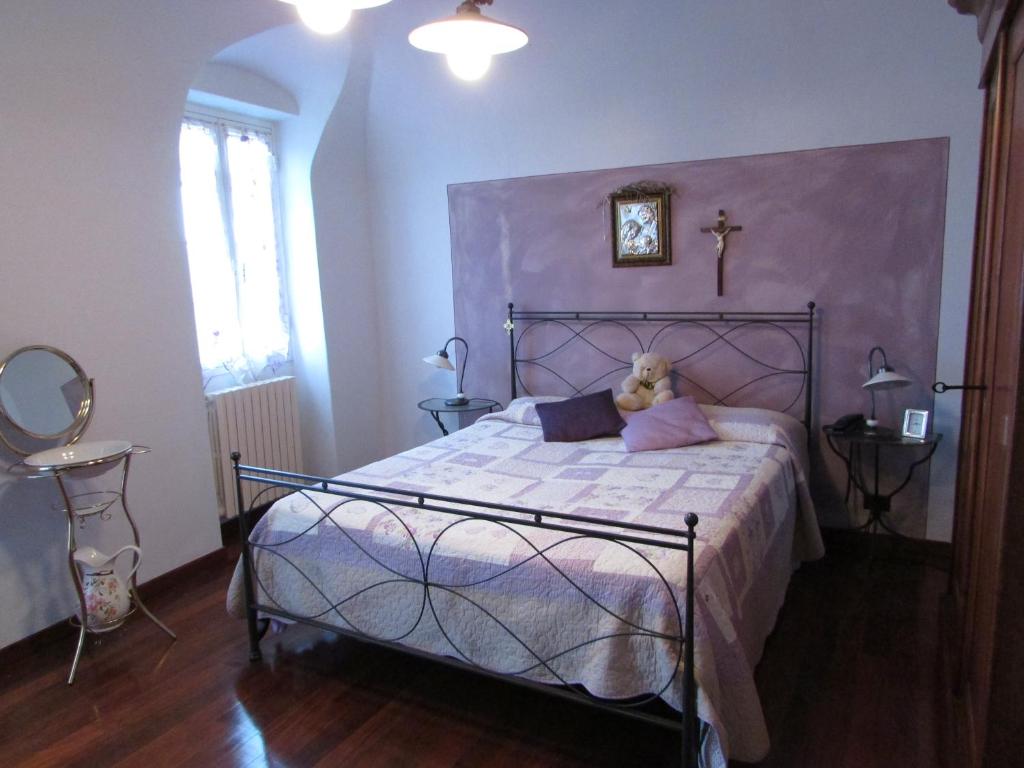 a bedroom with a bed with a teddy bear on it at Casa Antica Rosetta in Dolcedo