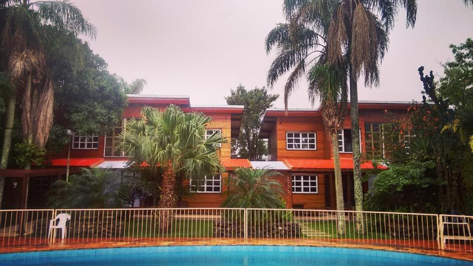 a building with a swimming pool in front of a house at San Willa's Hotel in São Miguel dʼOeste