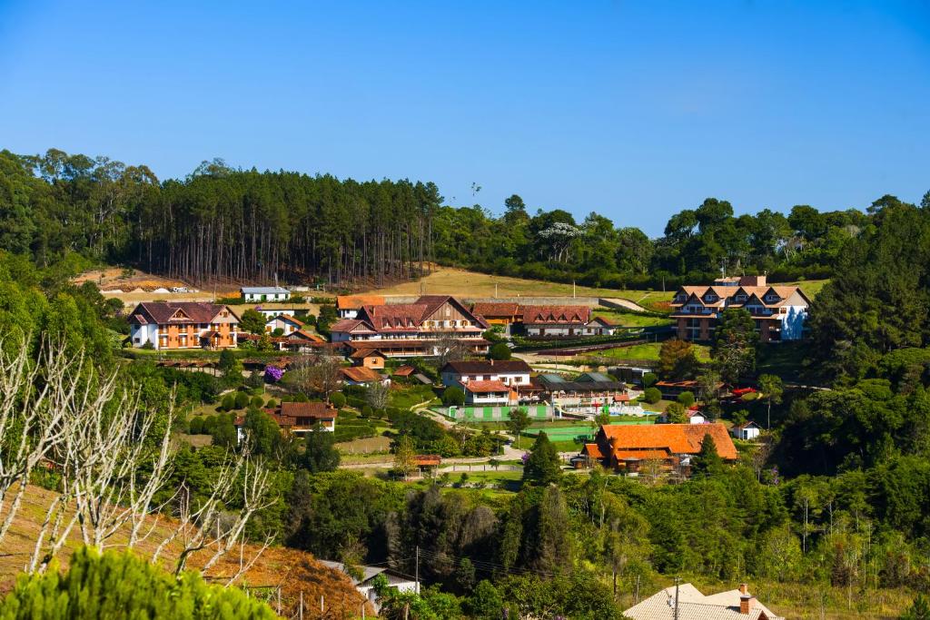 uma aldeia numa colina com casas e árvores em Pousada dos Pinhos em Pedra Azul