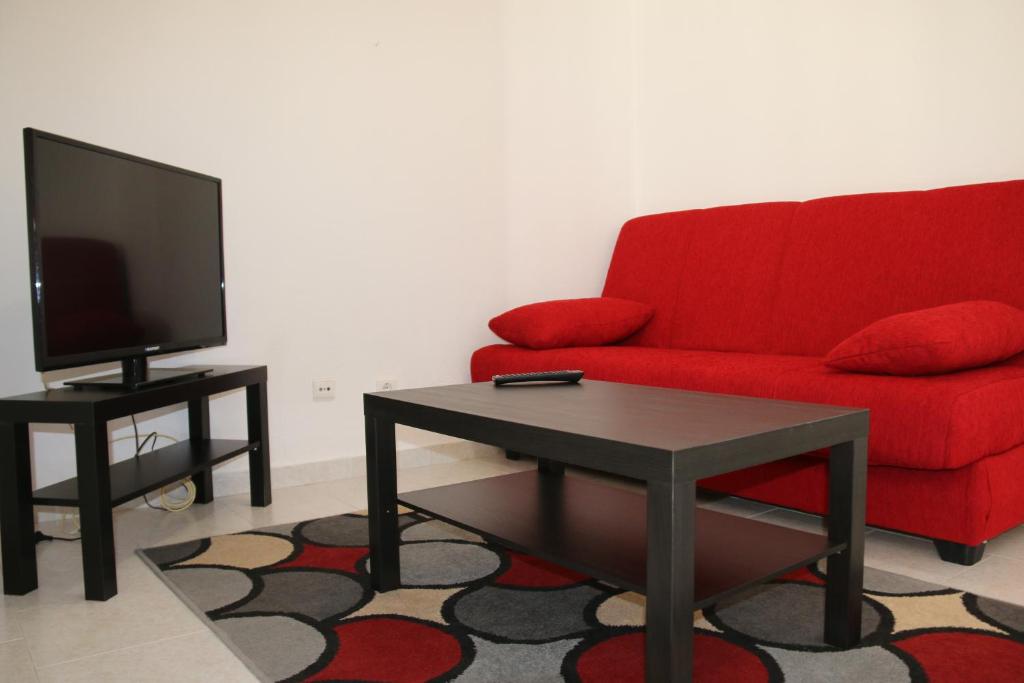 ナザレにあるDuplex na Nazaréのリビングルーム(赤いソファ、テレビ付)