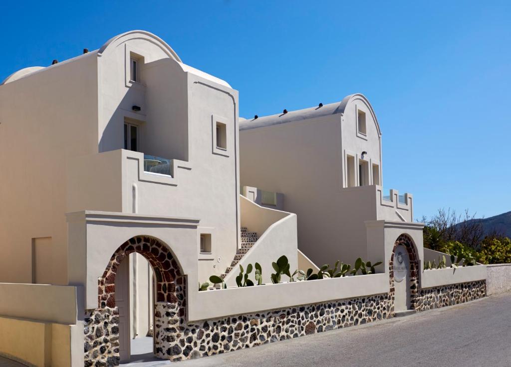 a white building with stairs and plants on it at Fileria Suites in Oia