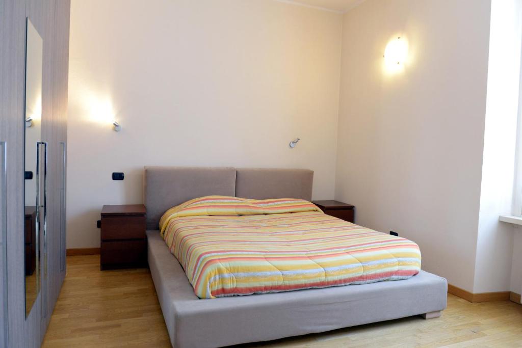 a bed with a striped blanket on it in a bedroom at Appartamenti Medioevo in Varese