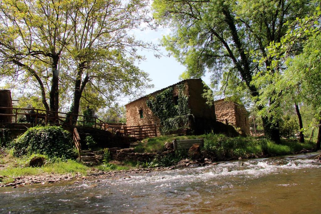 un antiguo edificio de piedra junto a un río en Sete Quintas en Miranda do Corvo