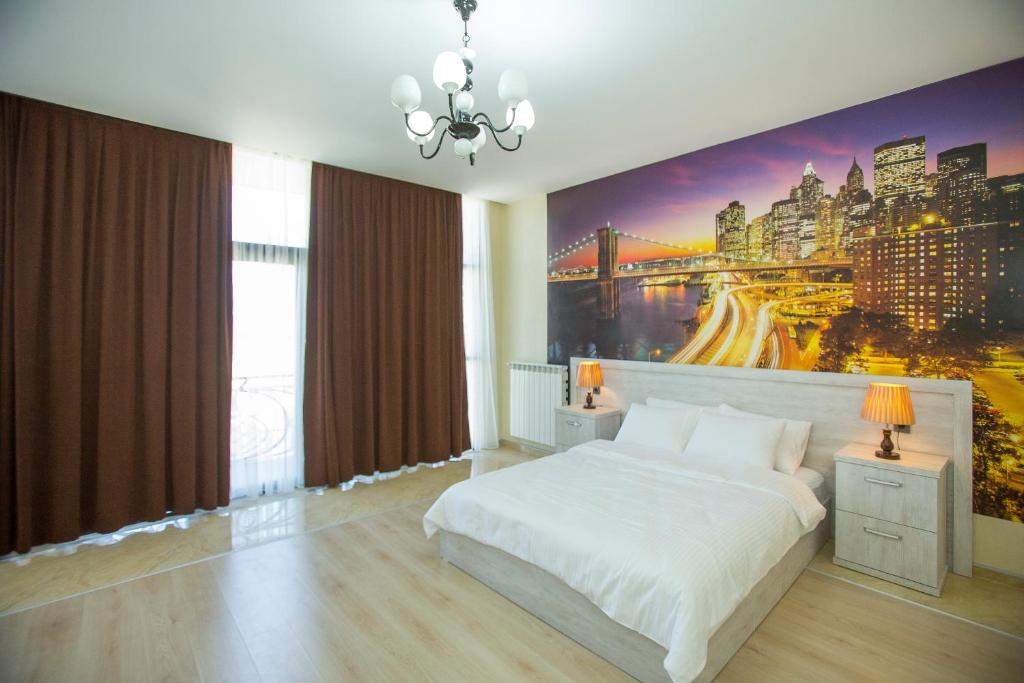 a hotel room with a large bed and a painting on the wall at Ire Palace in Batumi