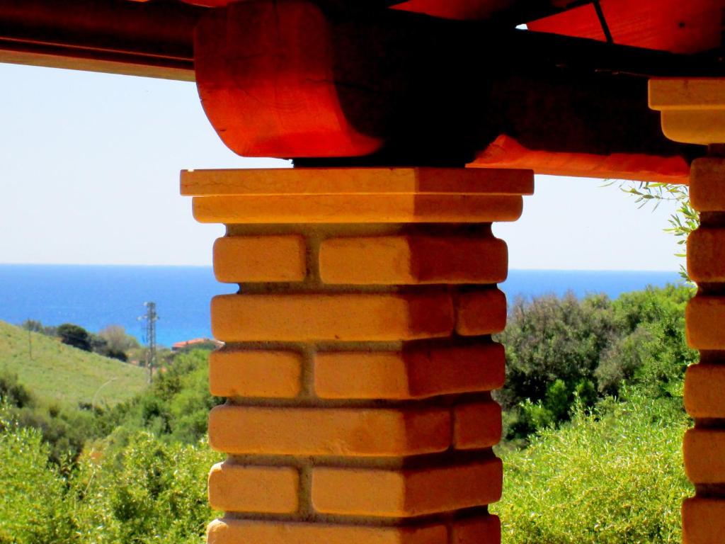 a view of the ocean from a brick wall at Sardinia Yellow House in Solanas