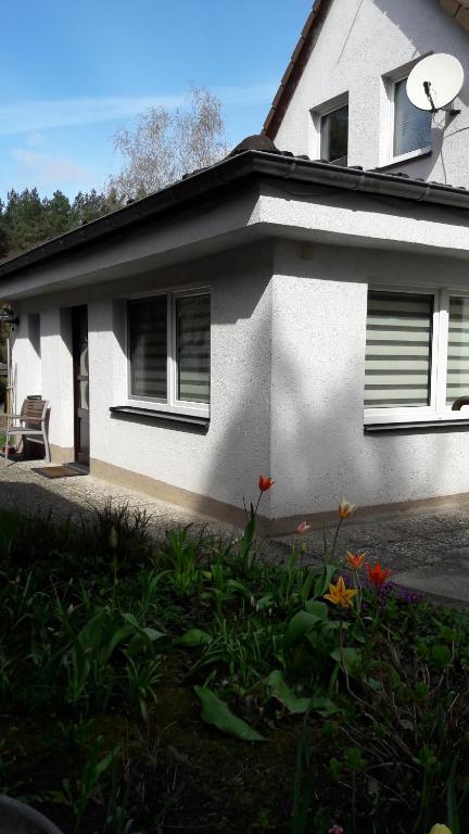 una casa blanca con un jardín delante de ella en Ferienhaus im Grünen/Monteurzimmer en Oranienburg
