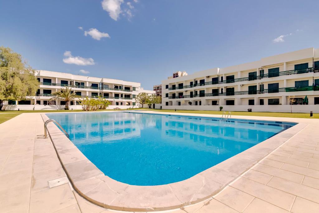 una gran piscina frente a un edificio en Victoria Studio en Vilamoura