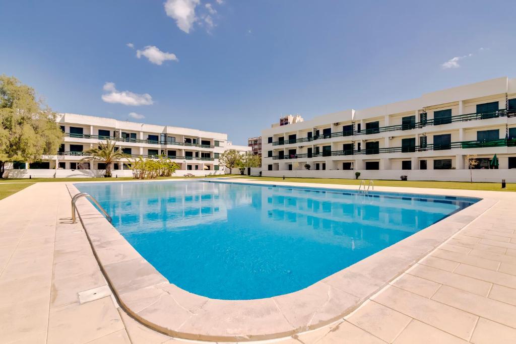 a large swimming pool in front of a building at Victoria Studio in Vilamoura