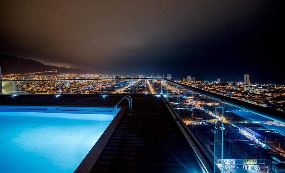 a view of a city at night with a swimming pool at Arriendo Diario Iquique in Iquique