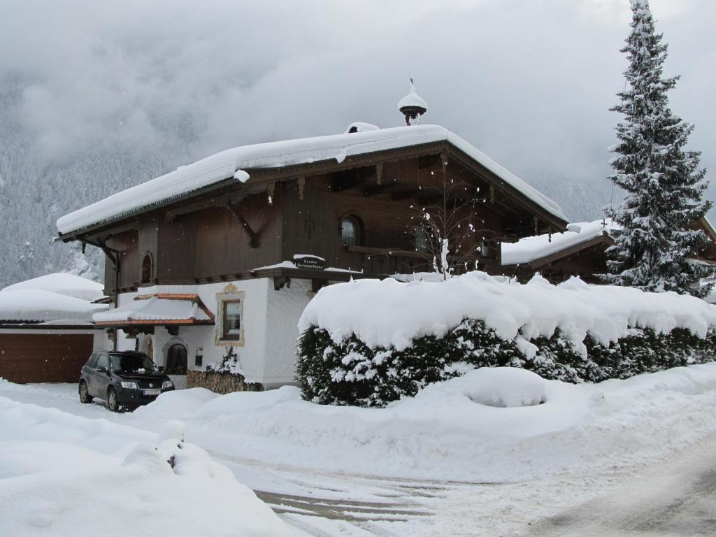 dom pokryty śniegiem z choinką świąteczną w obiekcie Apartment Gredler Maria w Mayrhofen