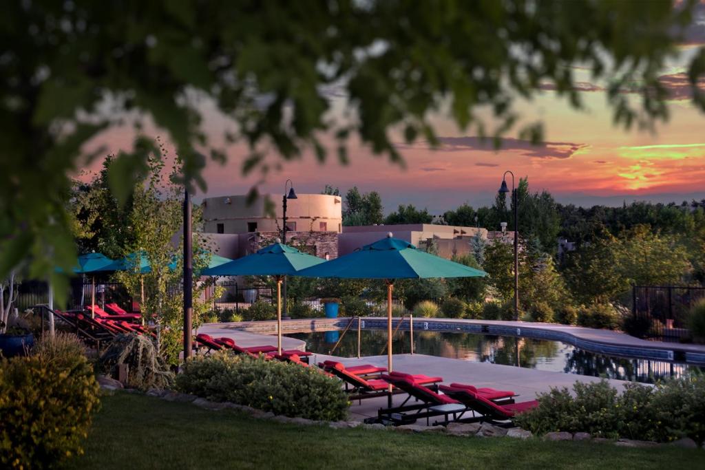 a pool with chairs and umbrellas and a resort at Four Seasons Resort Rancho Encantado Santa Fe in Santa Fe