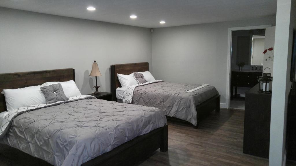 a bedroom with two beds and a dresser with a mirror at Lily's Lodge in West Springfield