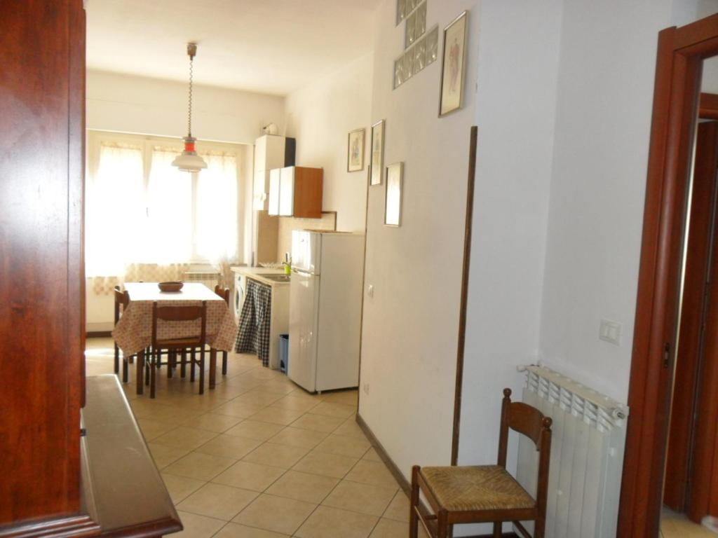 a kitchen with a refrigerator and a table with chairs at Parri Apartment in Follonica