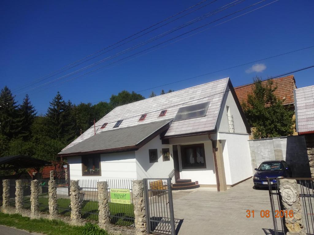 ein weißes Haus mit grauem Dach in der Unterkunft Chalupa pri vodopade in Lúčky