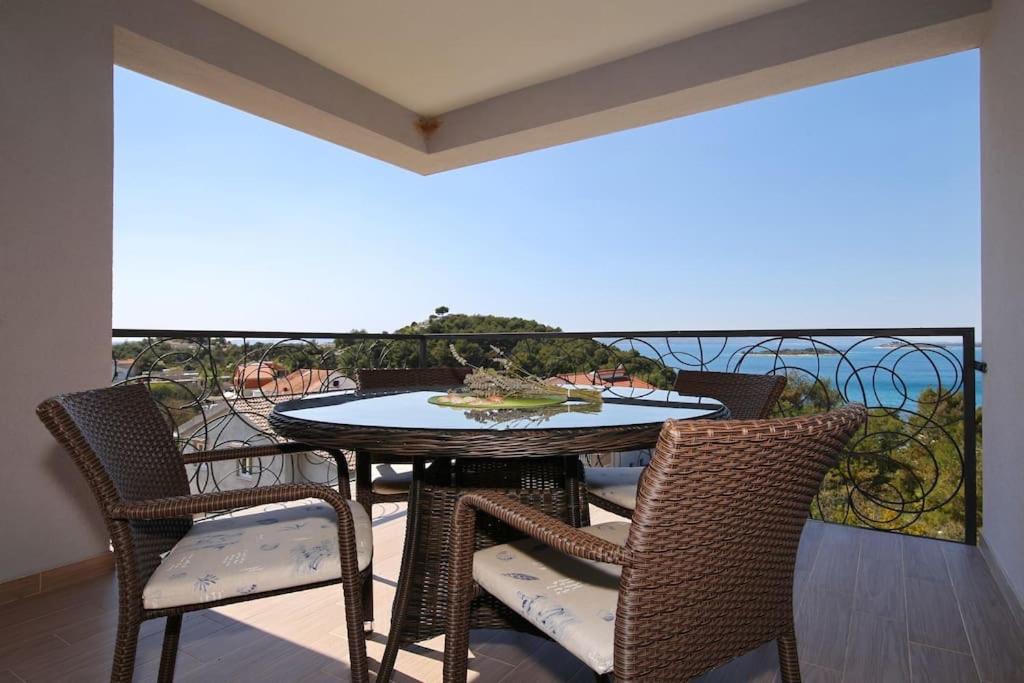 uma mesa e cadeiras numa varanda com vista para o oceano em Oleandra Apartments em Drage