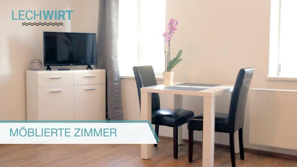 Pokój ze stołem z 2 krzesłami i telewizorem w obiekcie Lechwirt w mieście Schongau