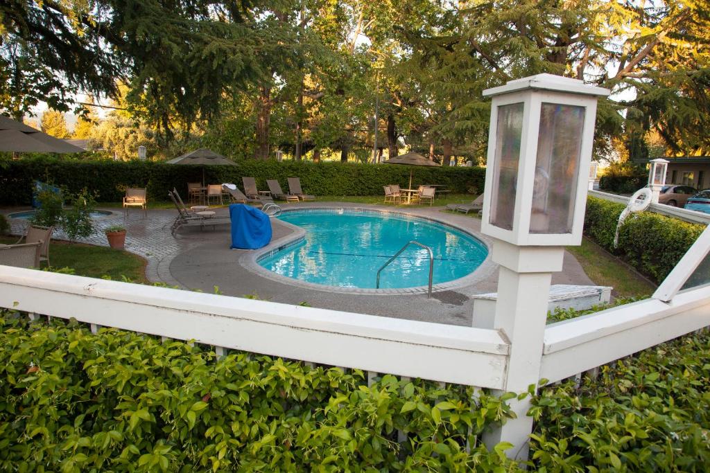 a white fence with a lantern next to a swimming pool at El Bonita Motel in St. Helena