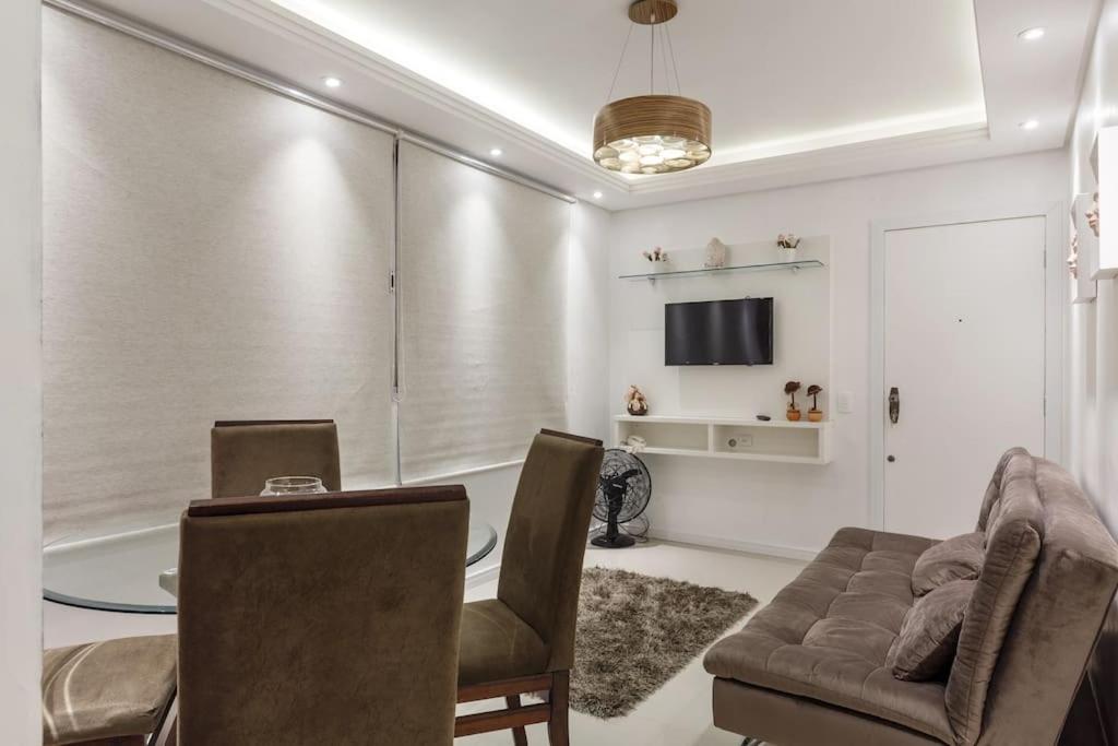a living room with a table and a couch and a television at Top Floripa Apartment in Florianópolis