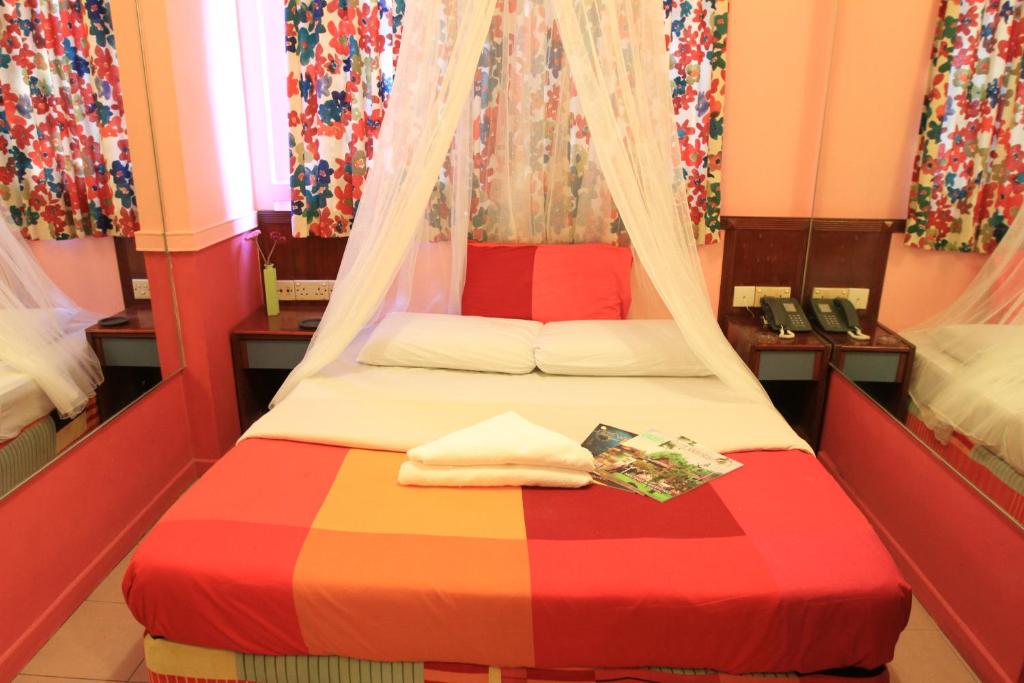 a bedroom with a bed with a colorful blanket at La Mode (Sophia) Hotel in Singapore