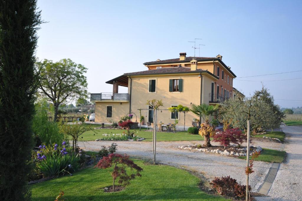 Una casa grande con un jardín enfrente. en Agriturismo Corte Albarel en Castelnuovo del Garda