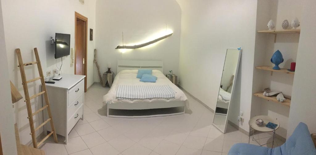 a white bedroom with a bed and a mirror at CasadAmare - Puglia Mia Apartments in Monopoli