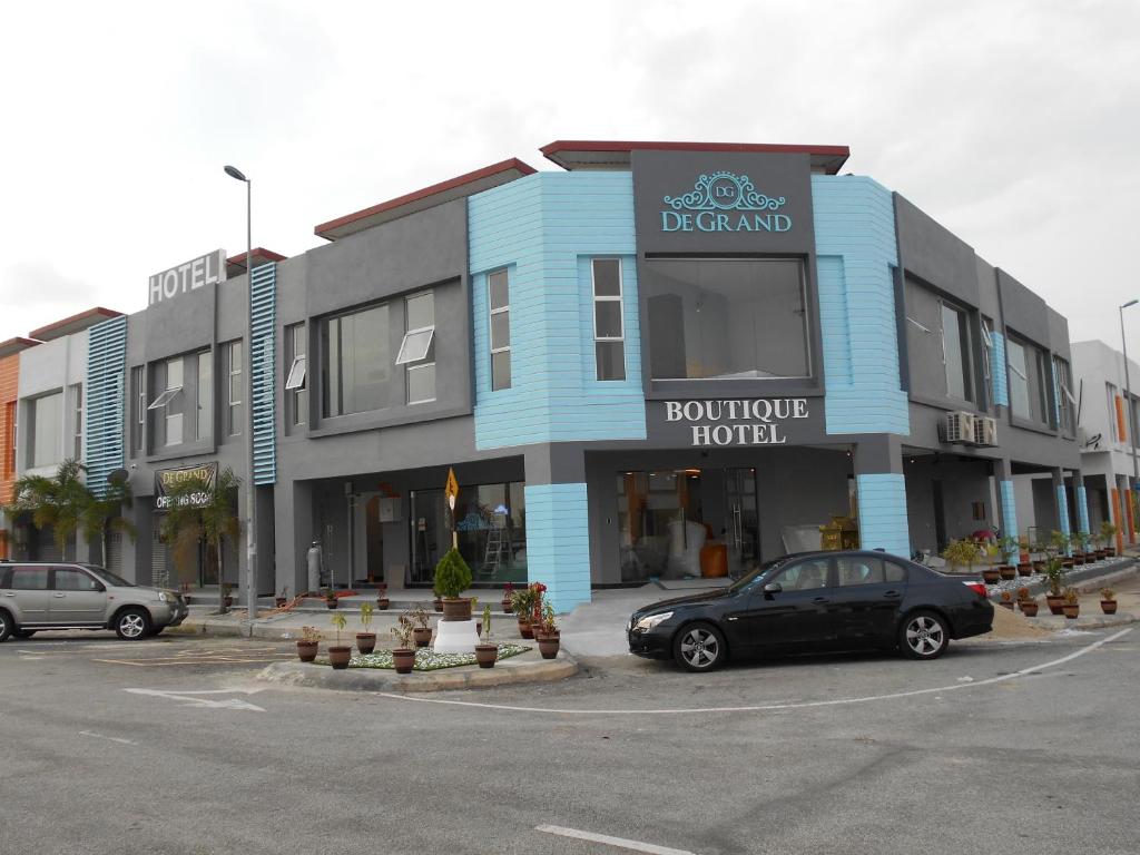 a black car parked in front of a hotel at PI Grand Hotel in Sepang