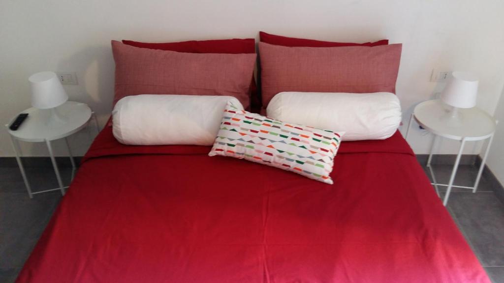 un letto rosso con due cuscini sopra di La Marina di Milano a Milano