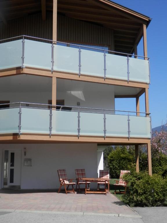 un edificio con un patio con mesa y sillas en Stubai Apartment Telfes, en Telfes im Stubai