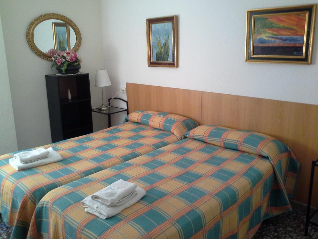 um quarto de hotel com uma cama com toalhas em Pensión Lacasta em Zaragoza