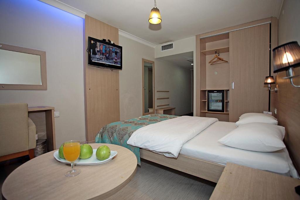 a hotel room with a bed and a table with a plate of fruit at Yildizoglu Hotel in Samsun