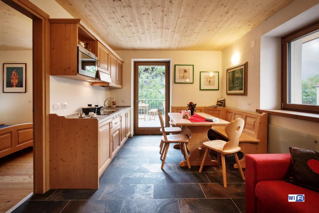 a kitchen with a table and chairs in a room at La Marmote Albergo Diffuso di Paluzza Testeons in Paluzza