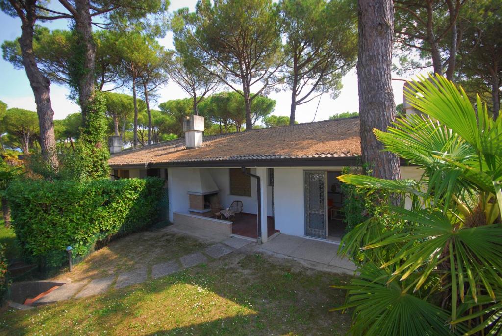 una piccola casa bianca con alberi in un cortile di Villa Mary a Lignano Sabbiadoro