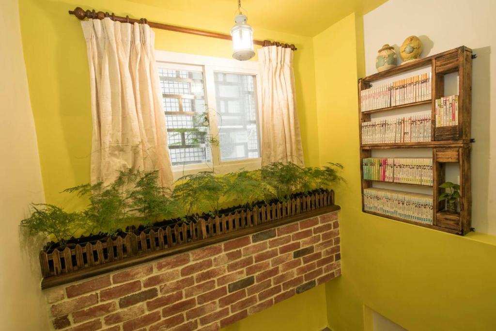 a window with plants on a brick ledge in a room at Dot Minsu in Wujie
