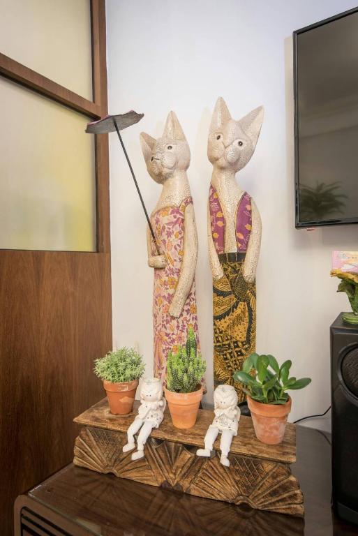 two statues of cats on a table with plants at Dot Minsu in Wujie