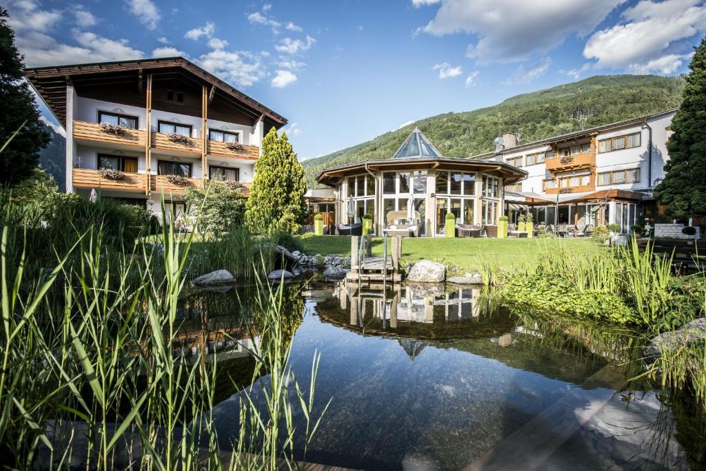 a hotel with a pond in front of it at Hotel Trattnig in Döbriach