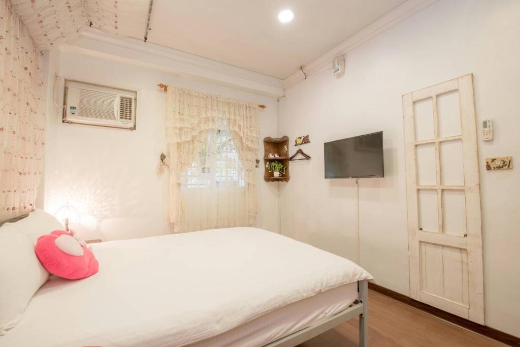 a bedroom with a white bed and a window at Dot Minsu in Wujie