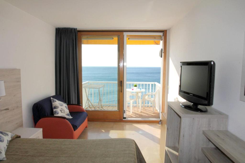 Habitación con TV y balcón con vistas al océano. en Hotel Maria Teresa, en Sant Antoni de Calonge