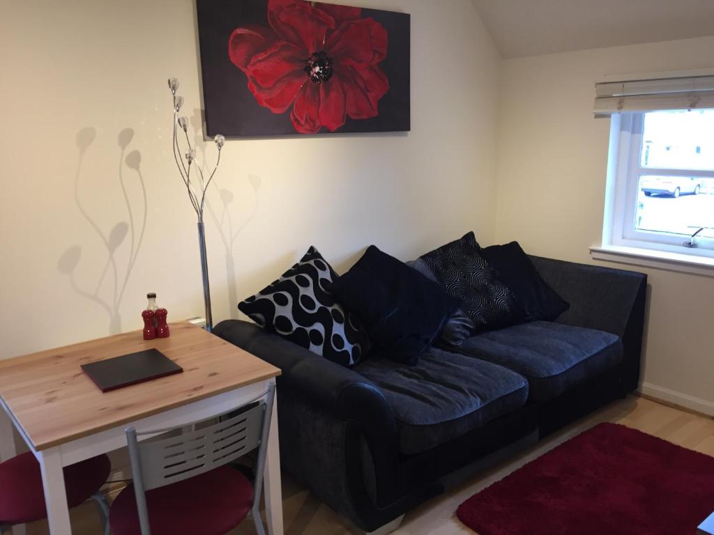 a living room with a blue couch and a table at 6 Varis Apartments in Forres